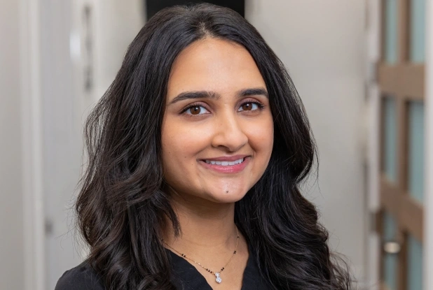 Professional portrait of a woman with long dark wavy hair smiling at Machesney Dental Studio
