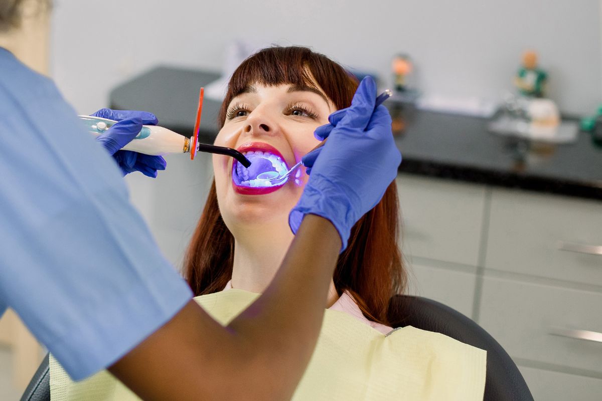 Patient receiving professional in-office teeth whitening treatment to remove coffee and tea stains and brighten their smile.