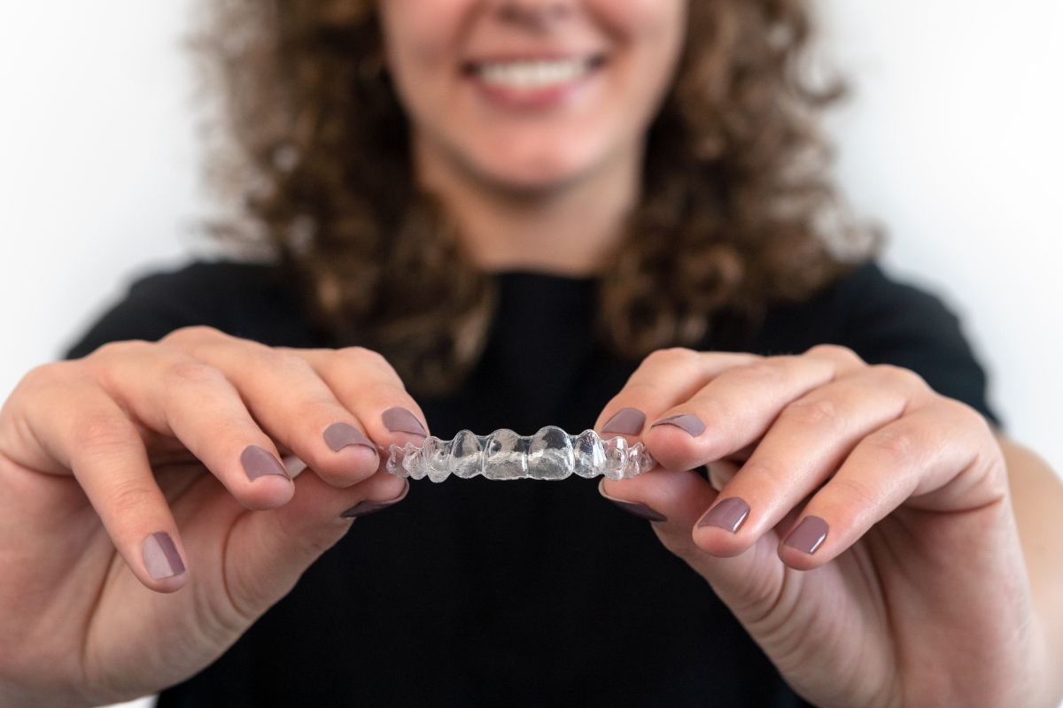 Patient holding clear aligners.